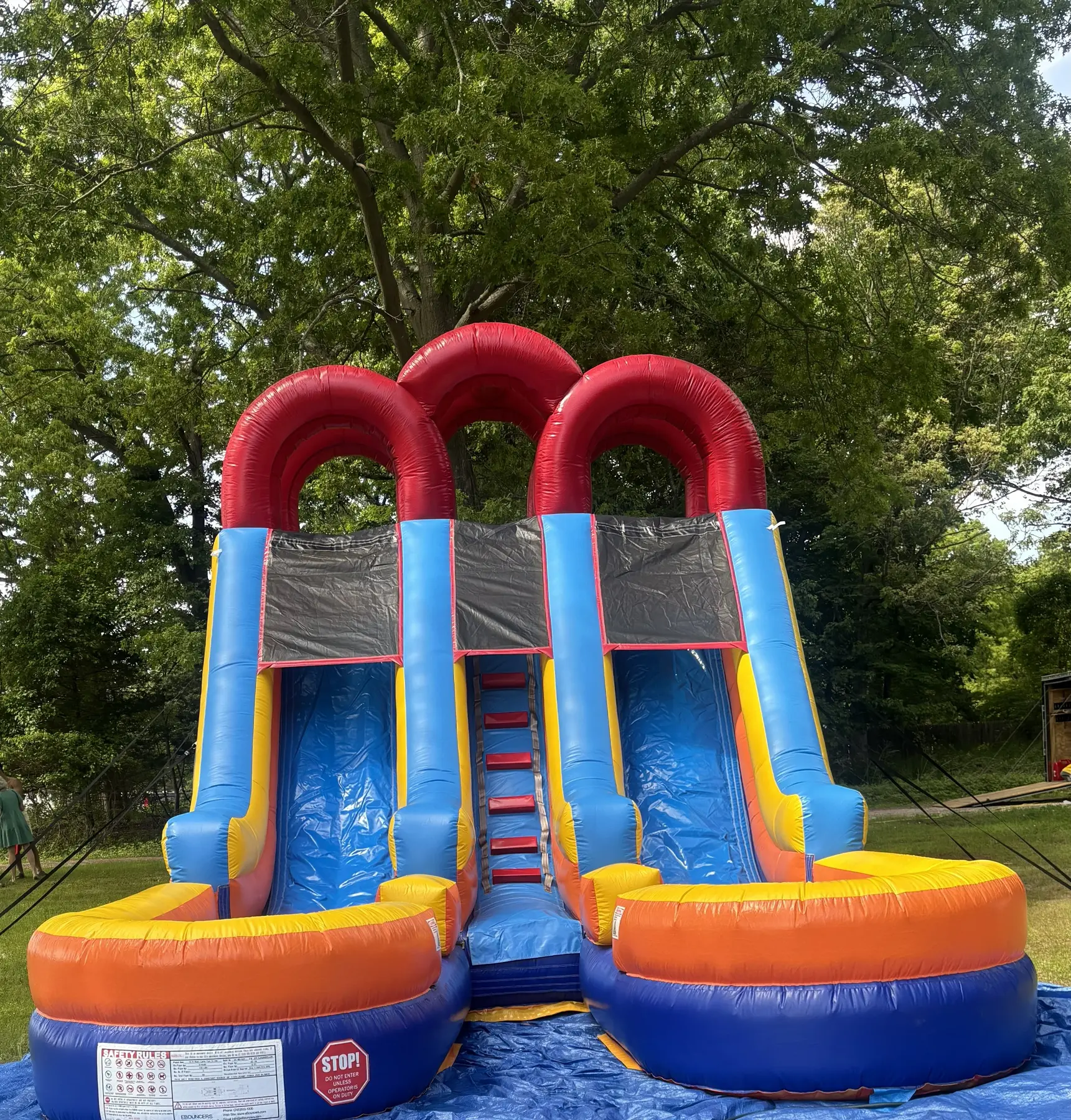 Colorful double-lane inflatable water slide set up on a lawn