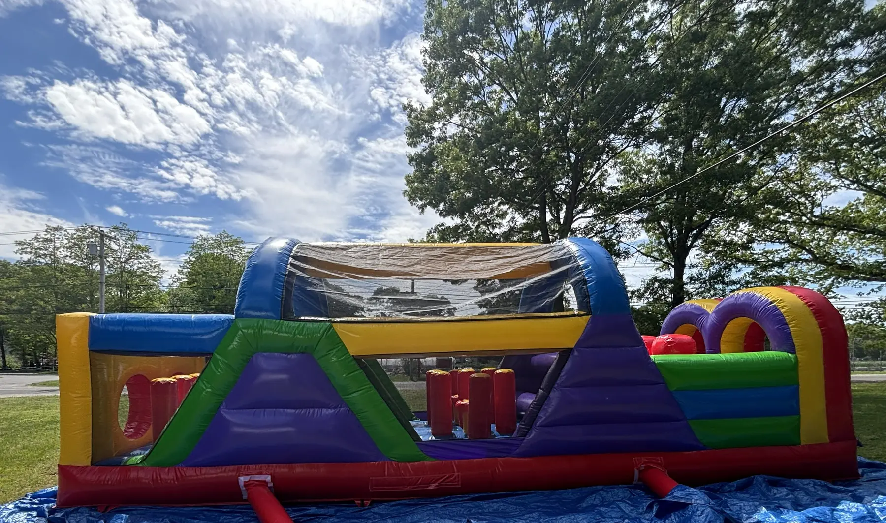 Colorful inflatable obstacle course set up outdoors under a bright sky